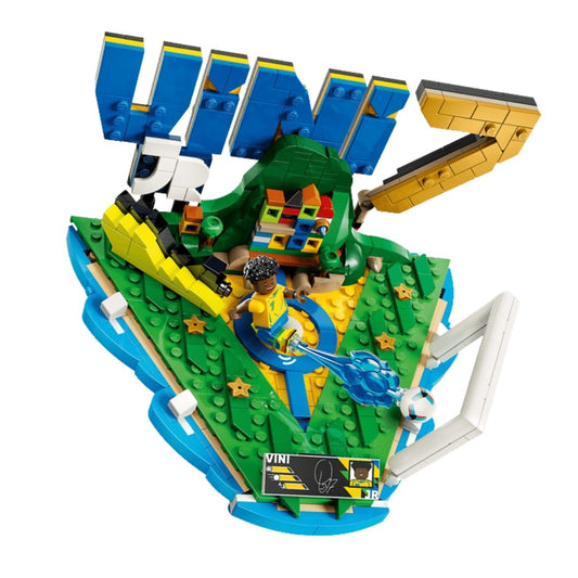 Top-down angled view of the completed LEGO Vini Jr. soccer pitch build, highlighting the goal net, stadium grass plates, and vibrant green, yellow, and blue typography.