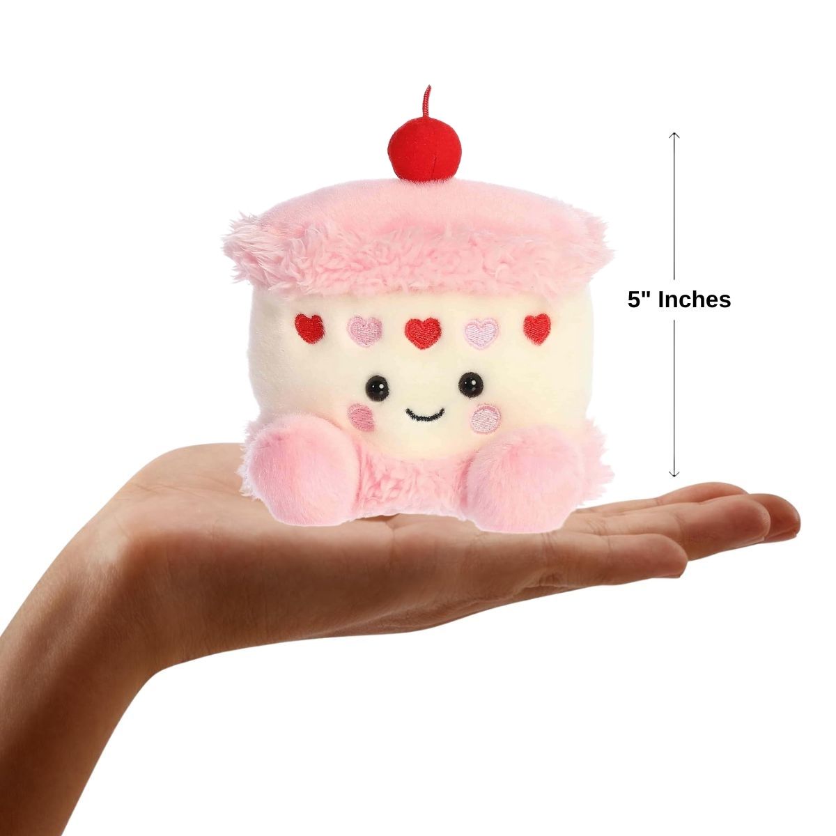Dimension graphic showing the 5-inch Aurora Palm Pals Jubi Heart Cake resting comfortably in a person's hand.