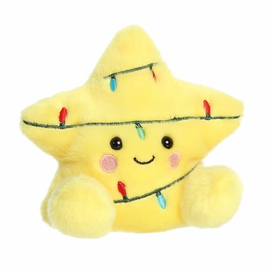 Yellow plush star toy with a smiling face and string lights on a white background