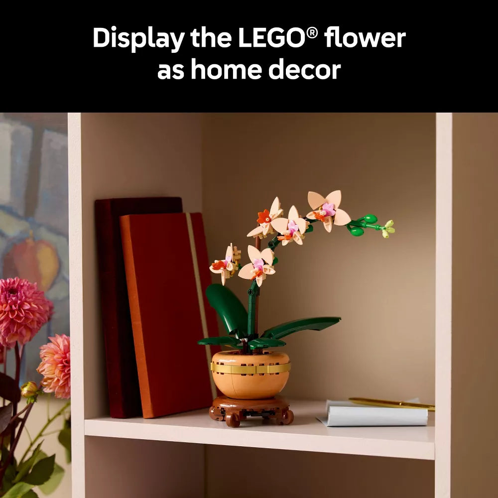 LEGO flower display on a shelf with books and a painting in the background