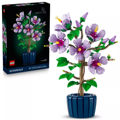 LEGO Botanicals set with purple flowers and green leaves in a blue pot, next to its packaging.