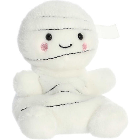 Aurora 5-inch Palm Pals Brendan Mummy plush toy showing its cream-white layered bandage body, dark stitched accent lines, and a sweet smiling face with rosy pink cheeks.