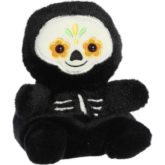Aurora 5-inch Palm Pals Santiago Sugar Skull plush toy showing its black body, white embroidered skeleton ribs, and a white face with orange, green, and yellow calavera embroidery.