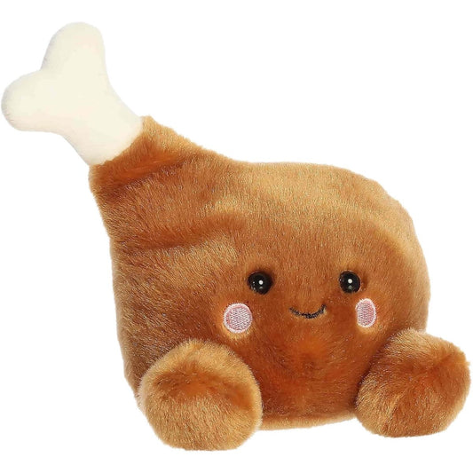 Aurora 5-inch Palm Pals Mila Drumstick plush toy sitting forward with golden-brown fabric, a soft bone top, and a smiling face.