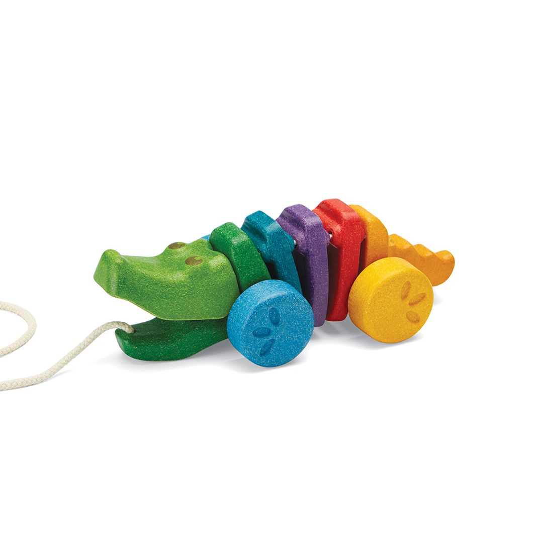 Angled view of the non-toxic PlanToys rainbow alligator pull toy ready for a walk.