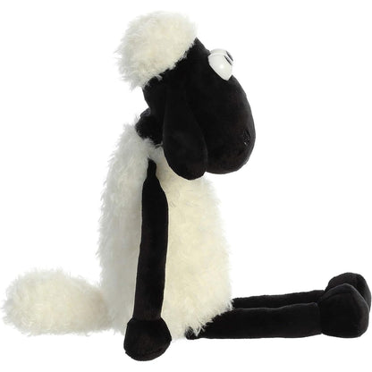 Side profile view of the Shaun the Sheep stuffed animal sitting, highlighting its plump white body and floppy legs.