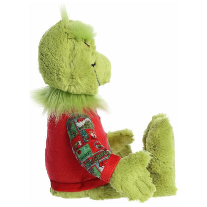 Side profile view of the sitting Grinch plush highlighting his fluffy neck fur, long green toes, and the fit of his red holiday sweater.