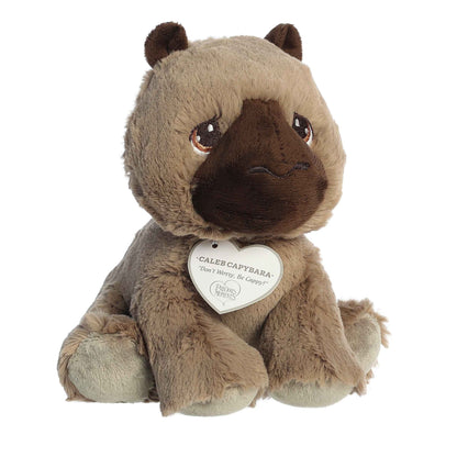 Front angled view of the 7-inch Aurora Precious Moments Caleb Capybara plush toy featuring shaggy brown fur and a white heart tag.