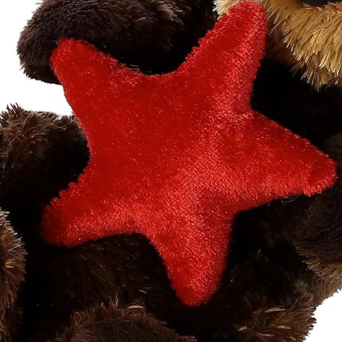Close-up view of the plush red starfish being held by the sea otter, highlighting the soft fabric texture.