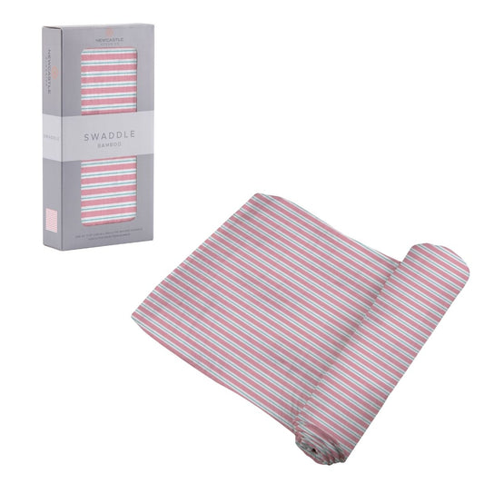 Newcastle Classics Candy Stripe pink and white bamboo swaddle blanket partially unrolled next to its grey retail packaging.