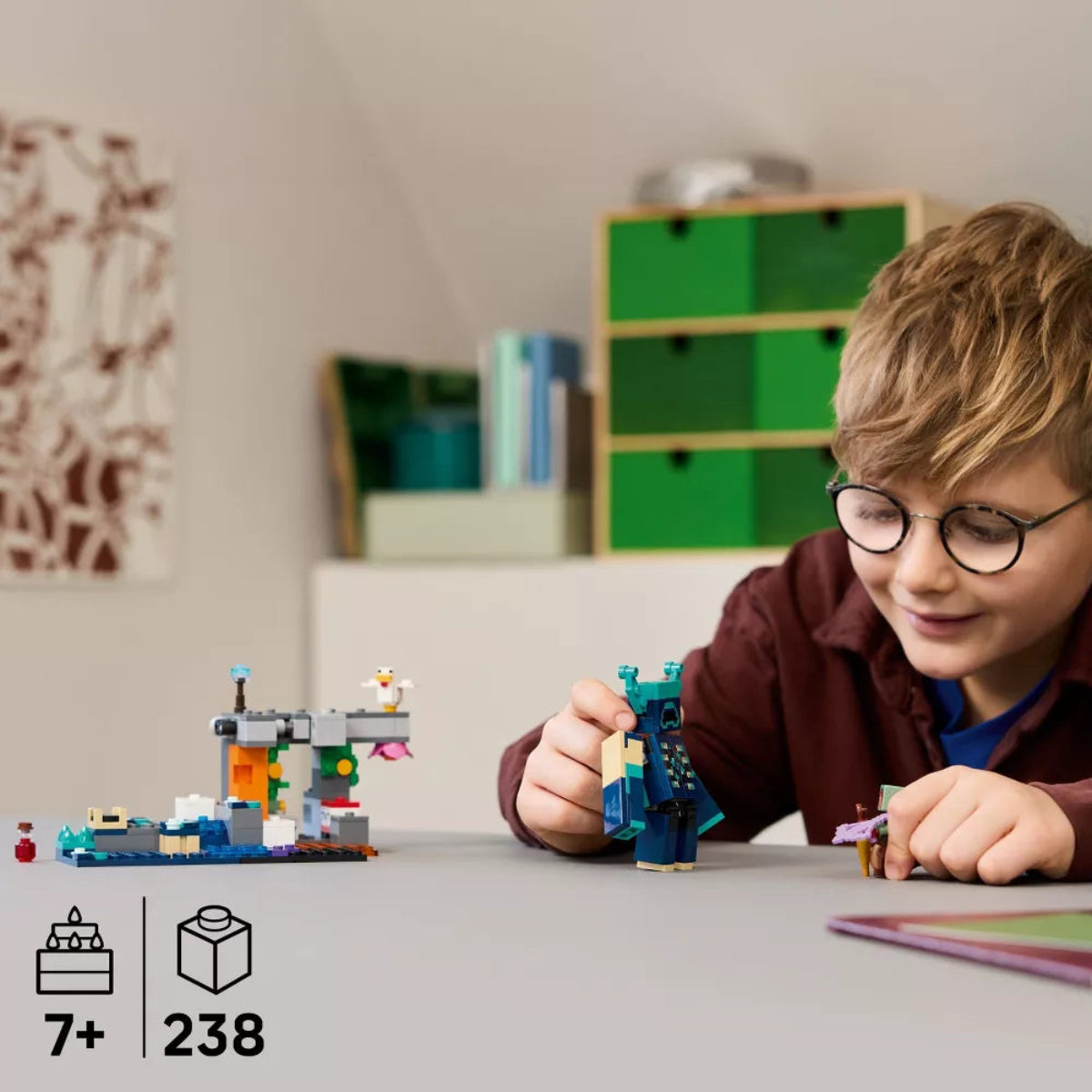 Child playing with LEGO sets on a table in a room with shelves in the background