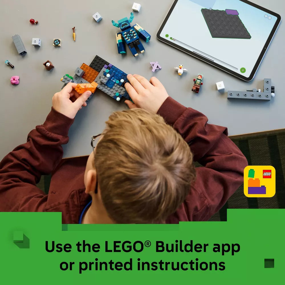 Child playing with LEGO bricks and using a tablet with a LEGO app on a gray surface.