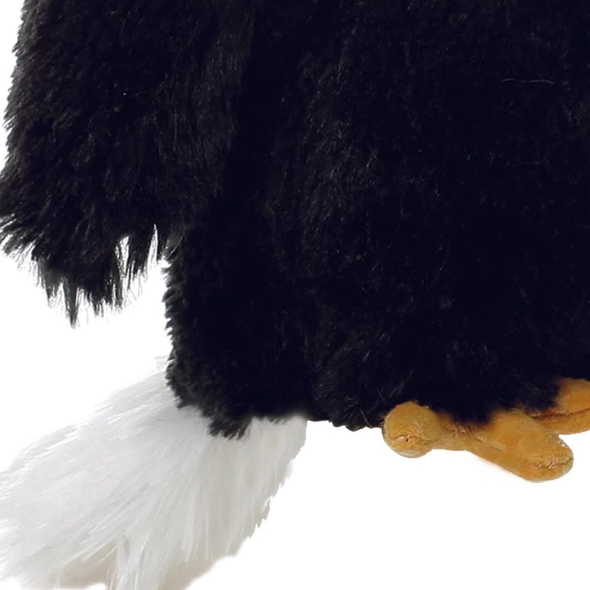 Close-up view of the eagle's tail feathers and talons, highlighting the soft white plush and golden-orange claw details.