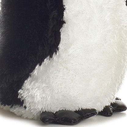 Close-up view of the soft penguin plush highlighting its fluffy white belly and black webbed feet.