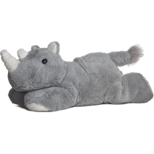 Angled side view of the Aurora Mini Flopsie Rhino 8-inch stuffed animal resting on its belly, featuring soft grey fur, two white horns, and a fluffy tail.
