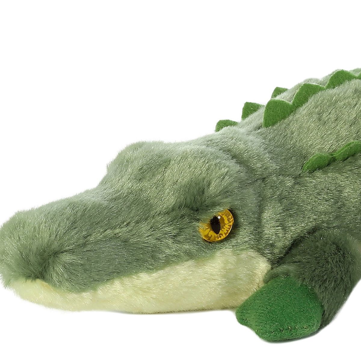 Close-up view of the adorable Aurora Swampy Crocodile stuffed animal featuring a long green snout, a striking yellow eye, and dark green front feet.