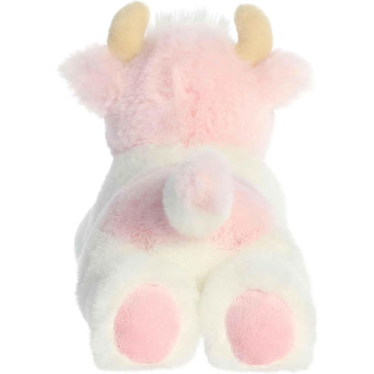 Rear view of the cow plush showing its pink tail, white back, and soft pink-accented hooves.