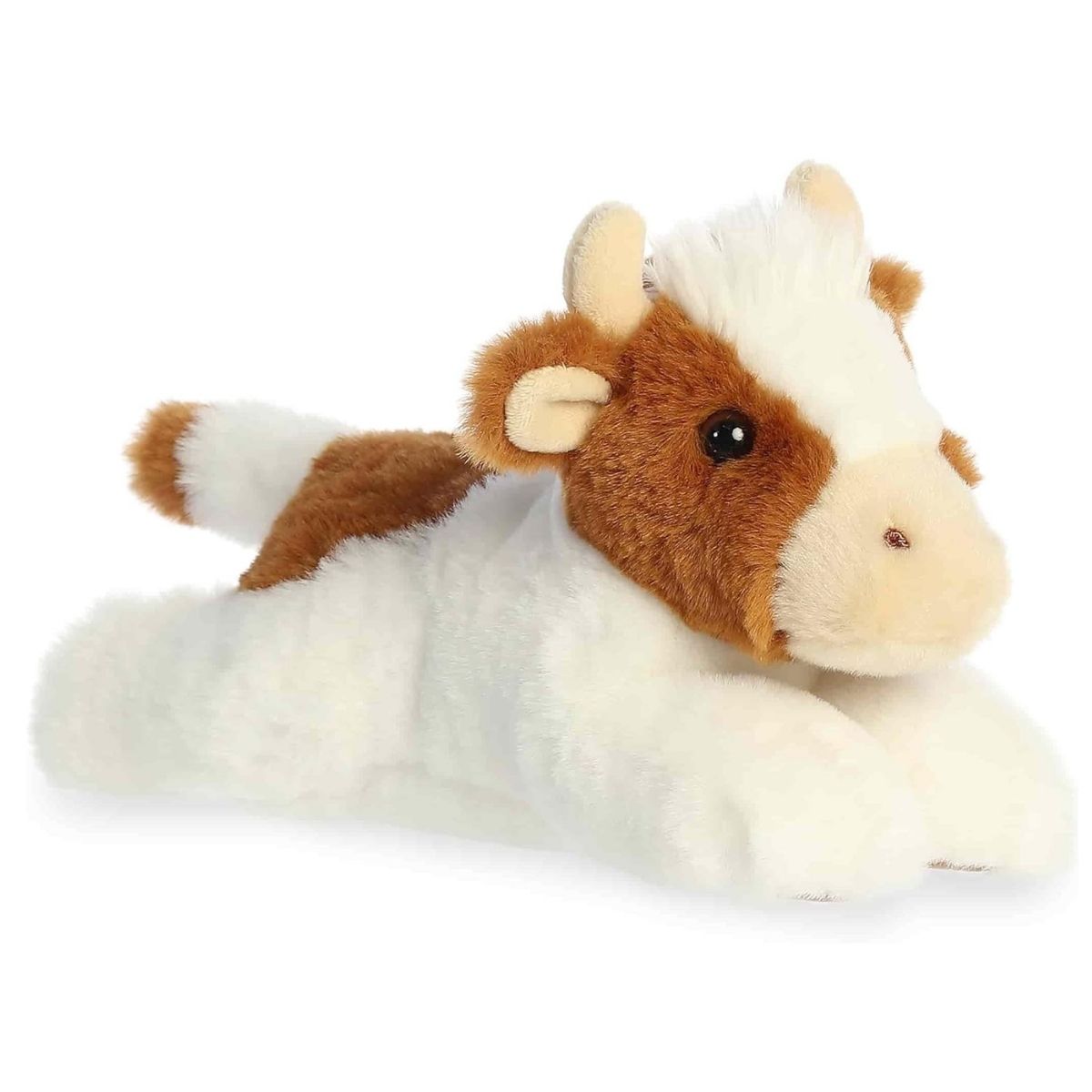 Angled view of the Aurora Flopsie 8-inch Grazy Guernsey Cow plush laying down, showing its brown and white patched fur and soft tan horns.