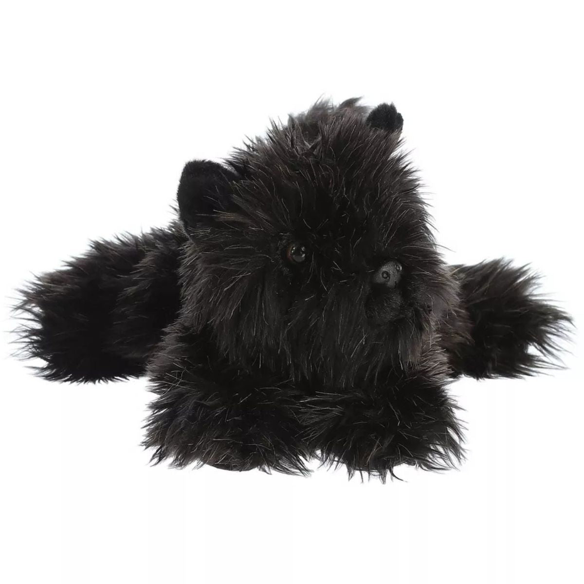 Direct front view of the scruffy black plush dog lying down, highlighting its pointed ears and fluffy face.