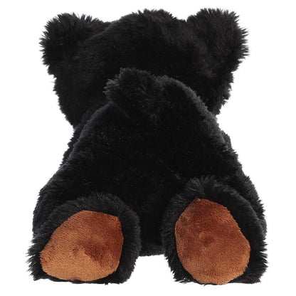 Rear view of the Sullivan Black Bear plush showing its dark black fur and the soft brown paw pads on its back feet.