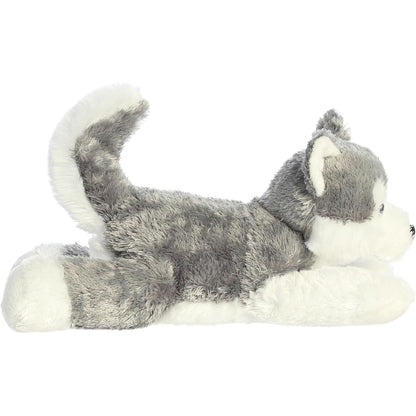 Side profile view of the cuddly Shadow dog stuffed animal resting comfortably on his tummy with his tail curled up.
