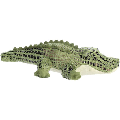 Angled side view of the Aurora Flopsie Alli Alligator 14-inch plush resting on its belly, featuring patterned green fur and soft ridges along its back.