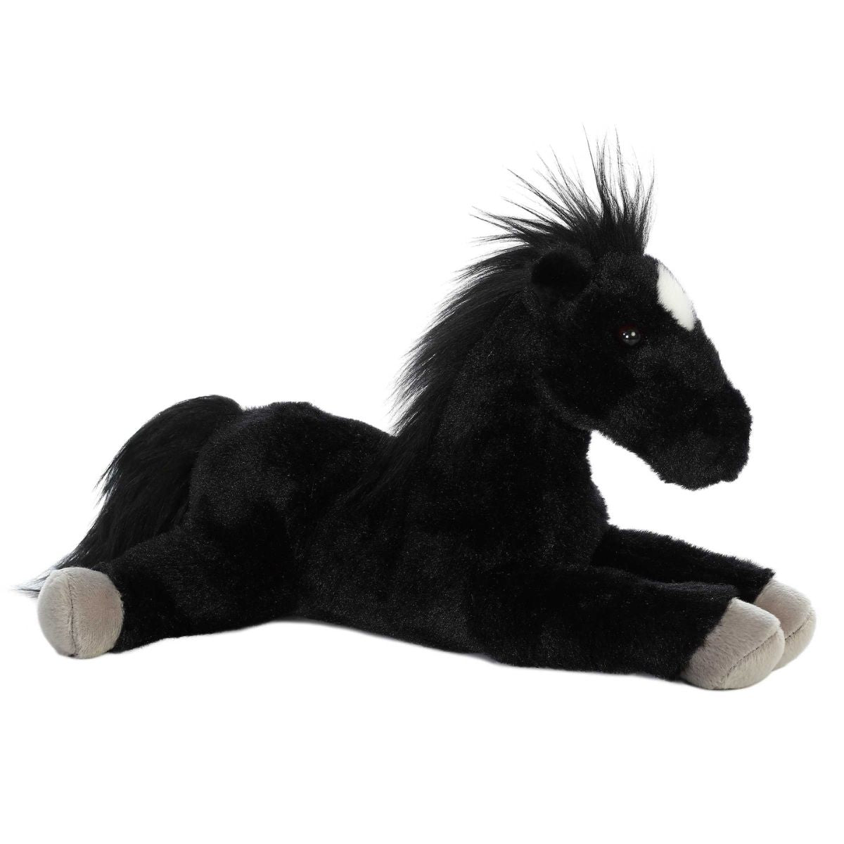 Angled side view of the Aurora Flopsie Blackjack the Black Stallion 12-inch plush resting on its belly, featuring solid black fur, a fluffy mane, and a white star marking.