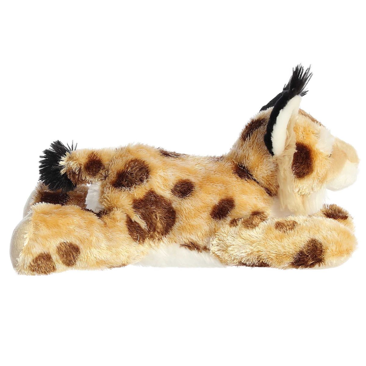 Side profile view of the spotted bobcat plush showing its lounging posture and signature short, black-tipped bobbed tail.