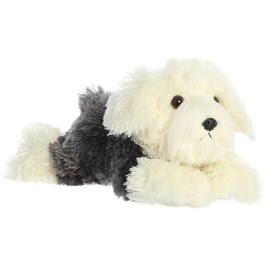 Angled side view of the Aurora Flopsie Edwin the Sheepdog 12-inch plush resting on its belly, featuring shaggy grey and cream fur.