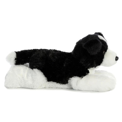 Side profile view of the cuddly Border Collie dog plush resting comfortably on its tummy, highlighting its white paws and belly.