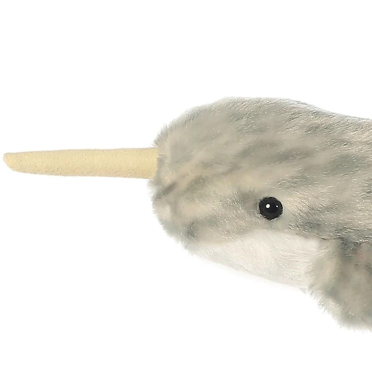 Close-up view of the narwhal's head highlighting its spiraled tan tusk and sweet dark eye.