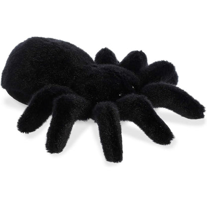 Angled view of the Aurora Mini Flopsie 8-inch Tod the Tarantula plush resting on its belly, showing its solid black body and eight legs.