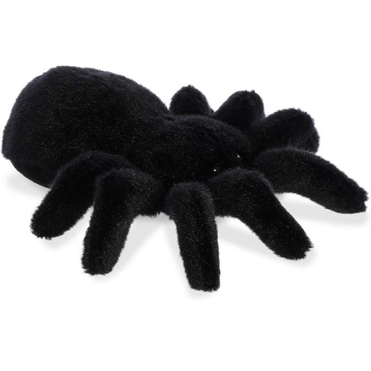 Angled view of the Aurora Mini Flopsie 8-inch Tod the Tarantula plush resting on its belly, showing its solid black body and eight legs.