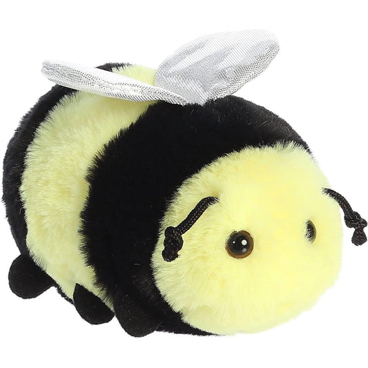 Angled front view of the 8-inch Aurora Mini Flopsie Beeswax the Bee stuffed animal resting on its tummy, showing its yellow and black stripes and shiny wings.