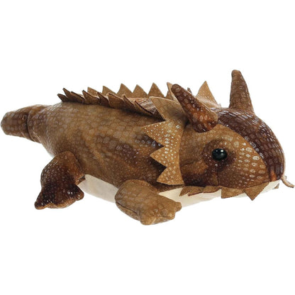 Angled side and front view of the 8-inch Aurora Mini Flopsie Patty Horned Lizard stuffed animal lying down.