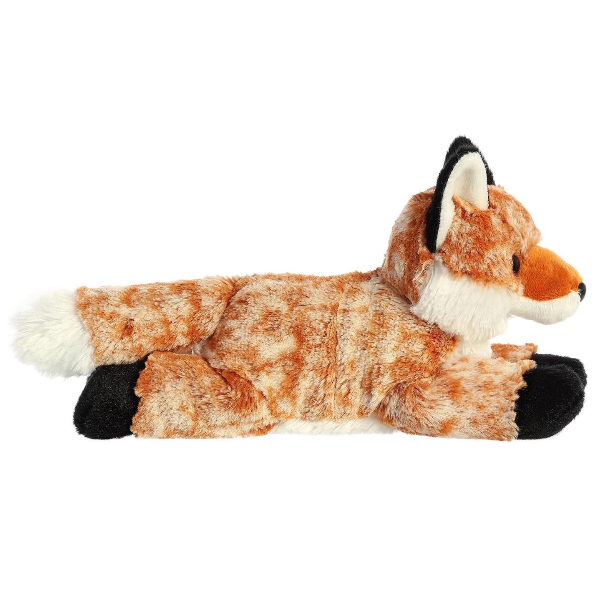Side profile view of the orange fox plush showing its lounging posture, light underbelly, and fluffy white-tipped tail.