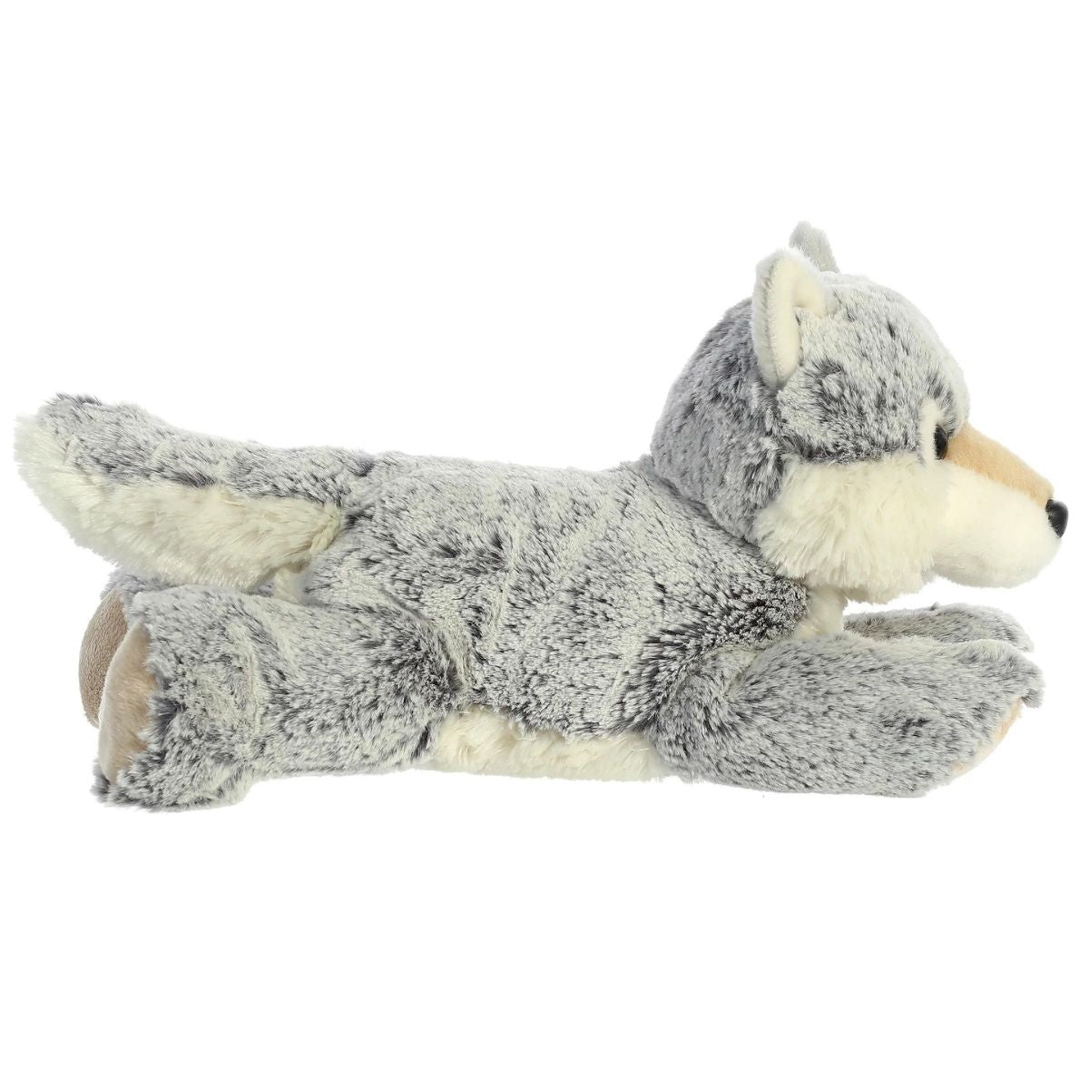 Side profile view of the grey wolf plush showing its lounging posture, fluffy tail, and light-colored underbelly.