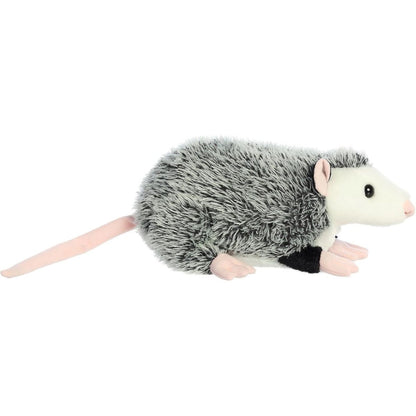 Side profile view of the grey opossum plush showing its lounging posture and long, soft pink tail.
