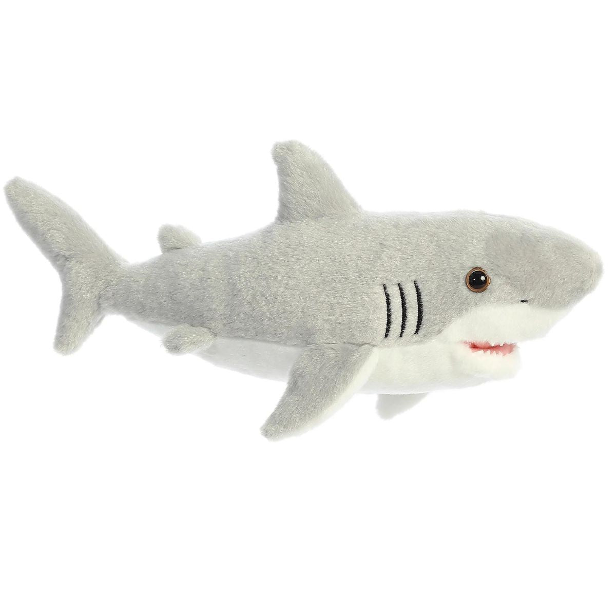 Angled side view of the Aurora Flopsie Great White Shark 12-inch plush resting on its belly, featuring a soft gray top, white underbelly, and dorsal fin.