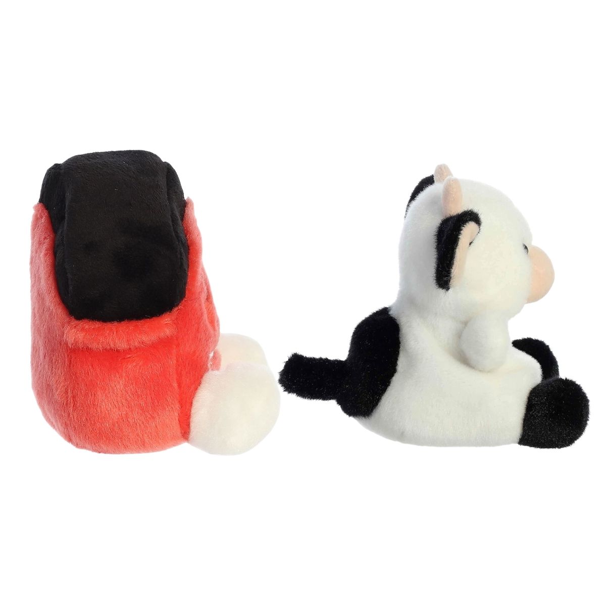 Side profile of the Aurora Palm Pals farm set highlighting the cow's black tail and the barn's shape.
