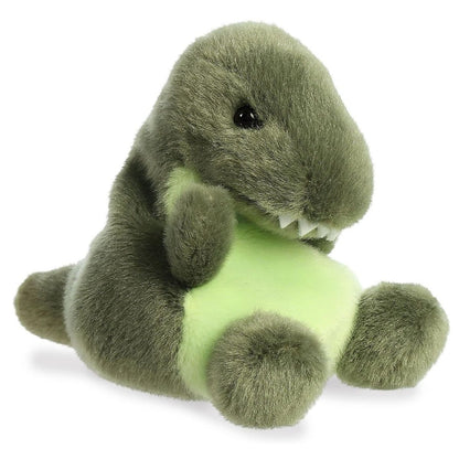 Angled view of the Aurora Palm Pals 5-inch Tyranno Rex T-Rex Dinosaur plush sitting upright, showing its dark green body, light green belly, and tiny arms.
