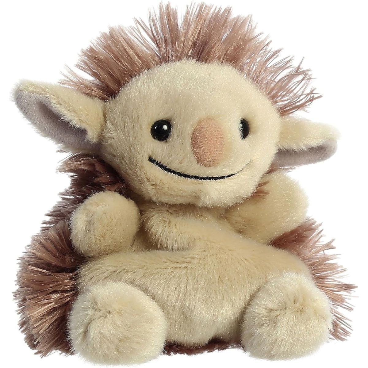 Aurora 5-inch Palm Pals Flick Pukwudgie plush toy sitting at an angle showing its tan plush face, fluffy spiky brown mane, large pointed ears, and wide stitched smile.
