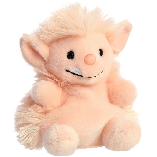 Aurora 5-inch Palm Pals Moh Ogre plush toy showing its soft peach-colored body, shaggy fuzzy hair mane, pointed ears, round nose, and smiling face with a single white tooth.