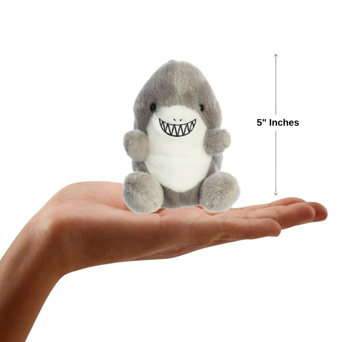 Sizing graphic for the Aurora Palm Pals Chomps Shark plush showing it sitting perfectly in the palm of a hand, indicating a total height of 5 inches.