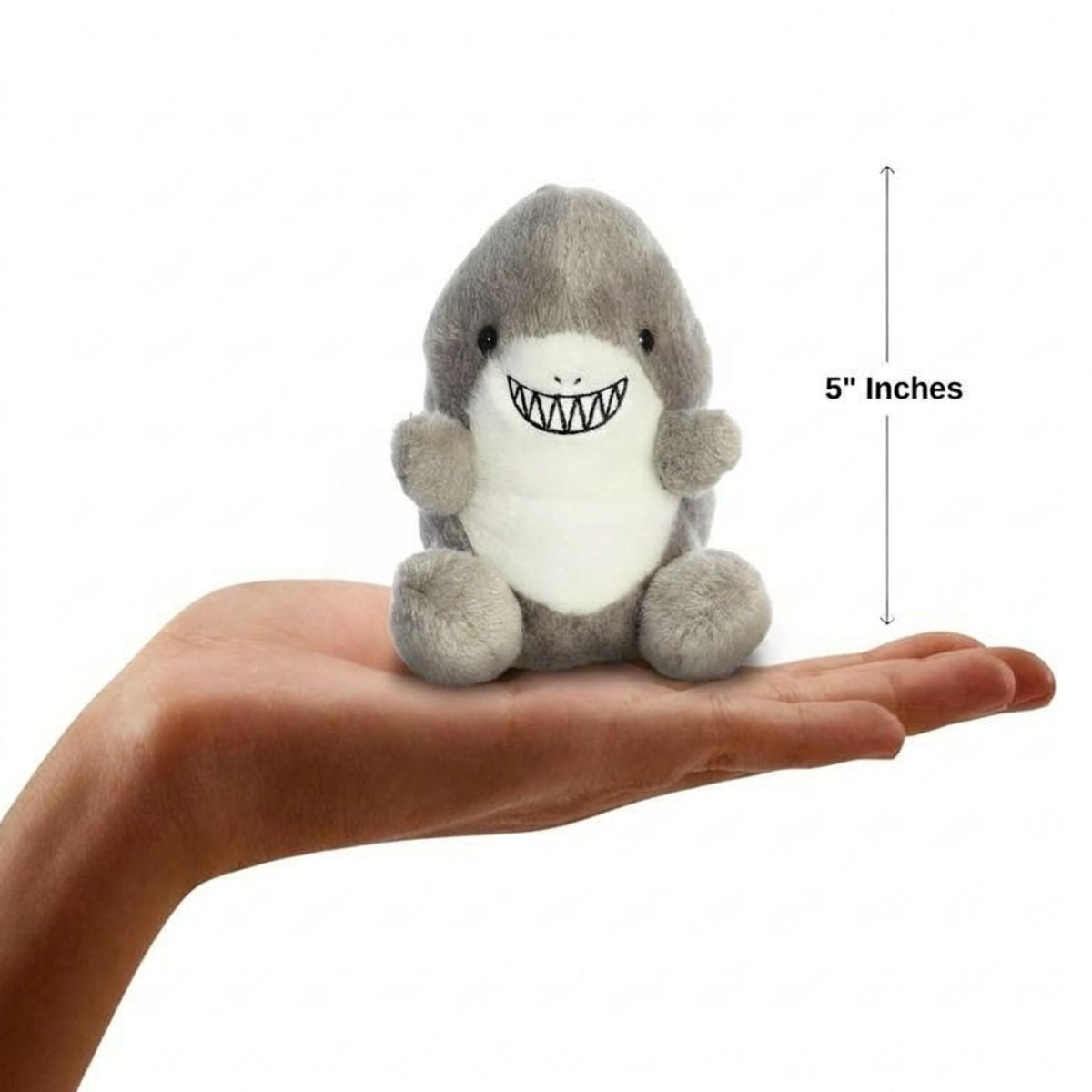Sizing graphic for the Aurora Palm Pals Chomps Shark plush showing it sitting perfectly in the palm of a hand, indicating a total height of 5 inches.