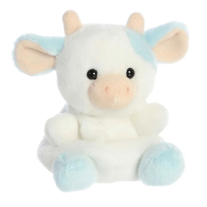 Aurora 5-inch Palm Pals Skyla Blueberry Cow plush toy sitting forward showing its white body, pastel blue eye patch and ears, peach horns, and a soft cream muzzle.