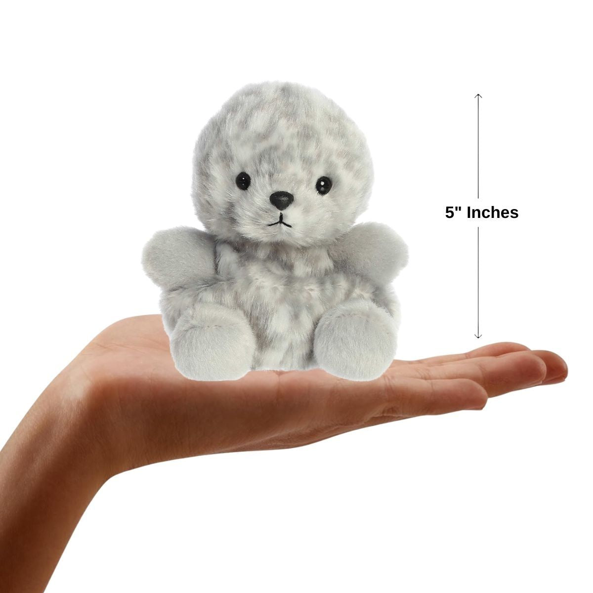 Sizing graphic for the Aurora Palm Pals Marina Harbor Seal plush showing it sitting perfectly in the palm of a hand, indicating a total height of 5 inches.