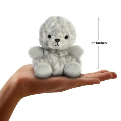 Sizing graphic for the Aurora Palm Pals Marina Harbor Seal plush showing it sitting perfectly in the palm of a hand, indicating a total height of 5 inches.