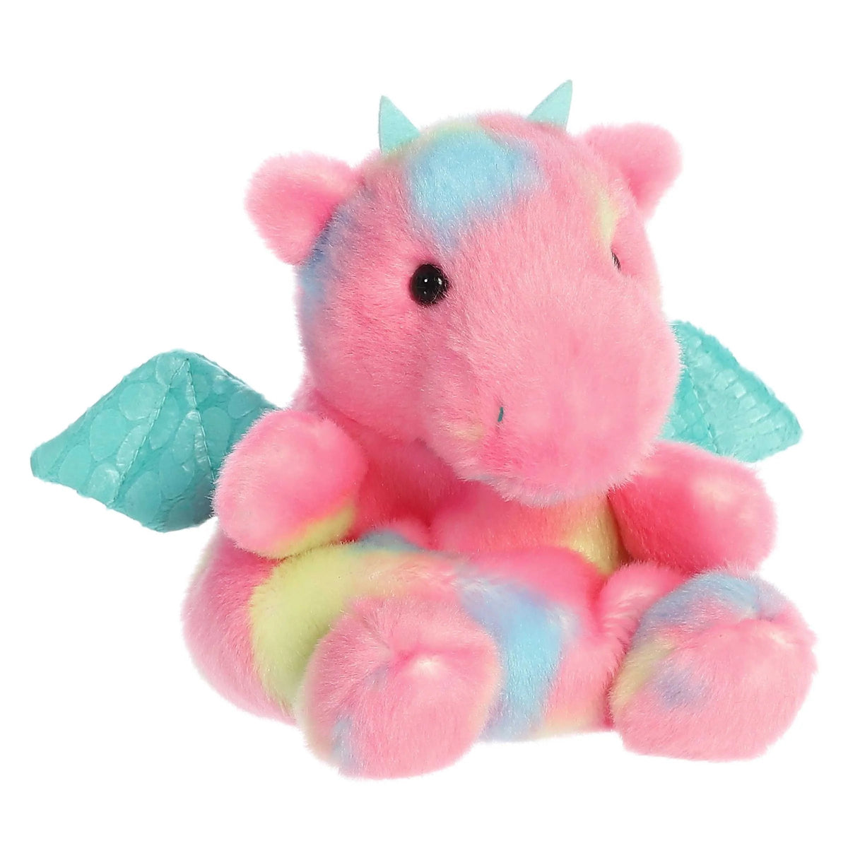 Plush toy dragon with pink body, blue wings, and multicolored accents on a white background