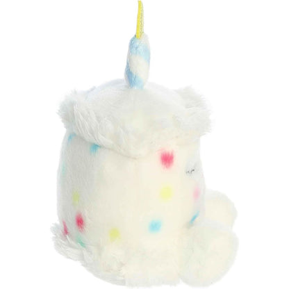 Side profile view of the Aurora Palm Pals cake plush highlighting its fluffy frosting brim and striped candle.